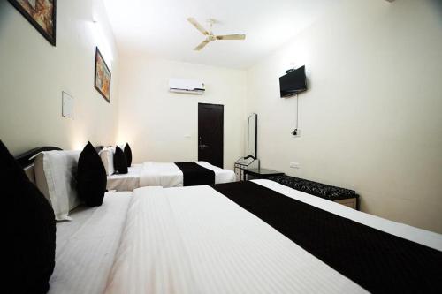 a hotel room with two beds and a ceiling fan at Hotel Lotus Inn near Udaipur City Railway Station in Udaipur