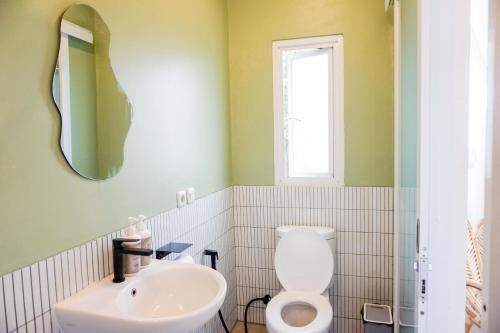 een badkamer met een wit toilet en een wastafel bij Over Easy Apartment in Bandung