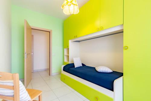 una camera da letto con pareti verdi e gialle e un letto di Appartamento Minerva int6 - MyHo Casa a Tortoreto