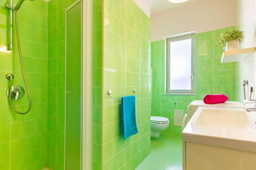 bagno verde con servizi igienici e lavandino di Appartamento Minerva int6 - MyHo Casa a Tortoreto