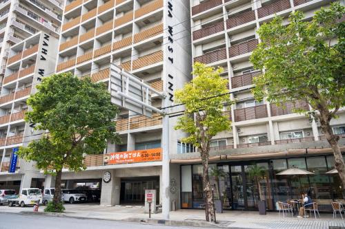 a tall building with trees in front of it at NAHA-WEST INN in Naha