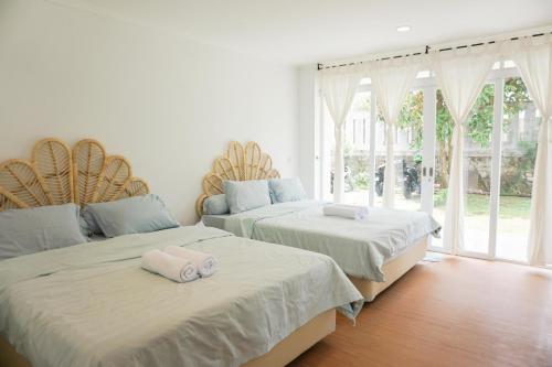 Duas camas num quarto com janelas em Over Easy Apartment em Bandung