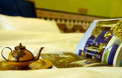 a teapot sitting on a bed next to a book at The Arabian Nights B&B in Chongqing