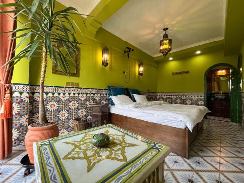 um quarto com uma cama, uma mesa e uma planta em The Arabian Nights B&B em Chongqing