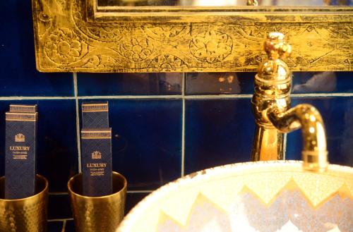 a bathroom with a gold faucet and a sink at The Arabian Nights B&B in Chongqing