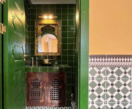 a green bathroom with a sink and a mirror at The Arabian Nights B&B in Chongqing