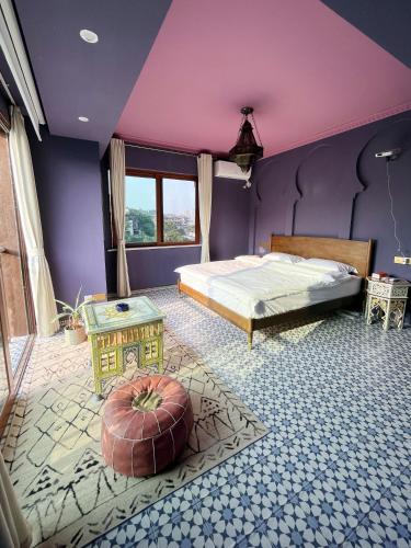 a bedroom with purple walls and a bed and a table at The Arabian Nights B&B in Chongqing