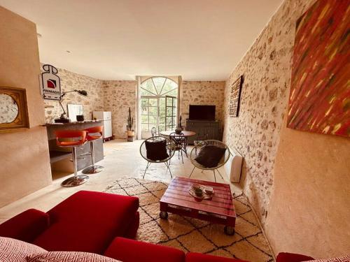 sala de estar con sofá rojo y mesa en Loft la Traversière, en Saint-Hippolyte-du-Fort