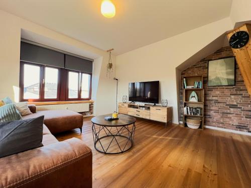 a living room with a couch and a tv at Cozy Apartment near city center Dresden by R&L in Dresden