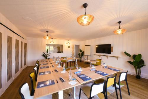 a conference room with long tables and chairs at Kyriad Villeneuve Saint Georges - Hôtel rénové in Villeneuve-Saint-Georges