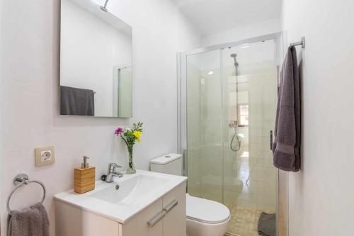 a bathroom with a sink and a toilet and a shower at Maca Sol, adosado con vistas a la montaña in Campanet