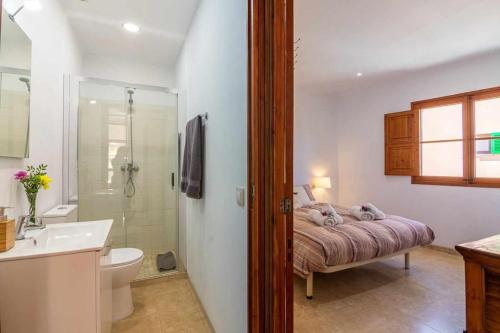 a bathroom with a bed and a shower and a sink at Maca Sol, adosado con vistas a la montaña in Campanet