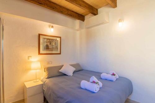 a bedroom with a blue bed with two pillows on it at Maca Sol, adosado con vistas a la montaña in Campanet