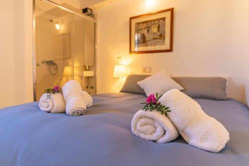 a bed with towels and flowers on top of it at Maca Sol, adosado con vistas a la montaña in Campanet
