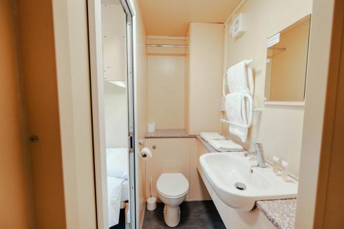 małą łazienkę z toaletą i umywalką w obiekcie IOMTT Village at Isle of Man TT w mieście Douglas