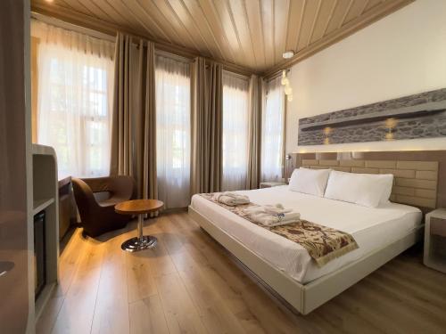 a bedroom with a large white bed and a chair at Puding Hotel in Antalya