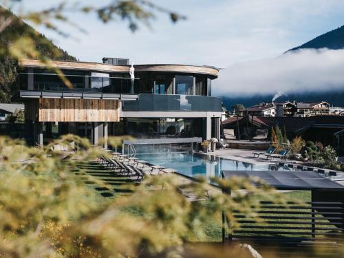 a house with a swimming pool and a mountain at Wagner's Aparthotel in Pertisau