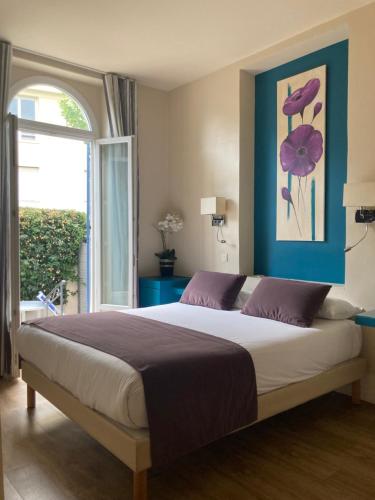 - une chambre avec un grand lit et une fenêtre dans l'établissement Hotel Le Havre Bleu, à Beaulieu-sur-Mer