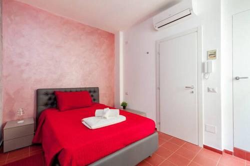 a bedroom with a red bed with a red blanket at L'inchiostro di Dante in Macerata