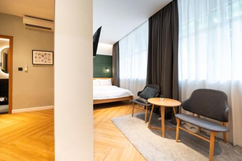 a hotel room with a bed and two chairs and a table at Habyt Cantonment - formerly Hmlet Cantonment in Singapore
