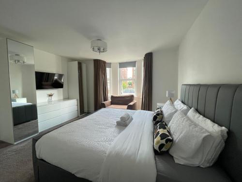 - une chambre avec un grand lit et une télévision dans l'établissement Holdsworth House Apartments, à Killingbeck