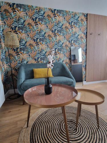 un salon avec un canapé bleu et une table dans l'établissement Le Cottage, à Quimper