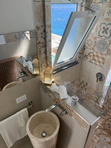 een badkamer met een wastafel en een spiegel bij Casa Positano in Positano