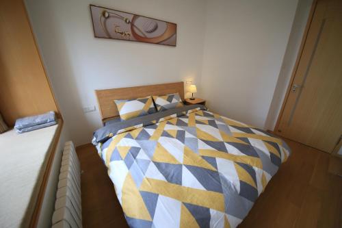 a bedroom with a bed with a blue and yellow comforter at Colorful Yunnan Absolutely Beautiful Dian B&B in Kunming