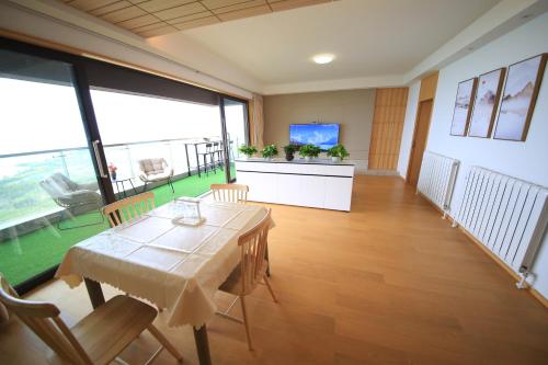 a dining room with a table and a large window at Colorful Yunnan Absolutely Beautiful Dian B&B in Kunming