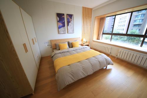 a bedroom with a bed with a yellow blanket at Colorful Yunnan Absolutely Beautiful Dian B&B in Kunming