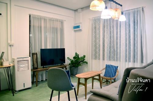 a living room with a couch and chairs and a tv at V1-Baan Borijinda-Wooden House in The old city of Chiang Mai in Chiang Mai