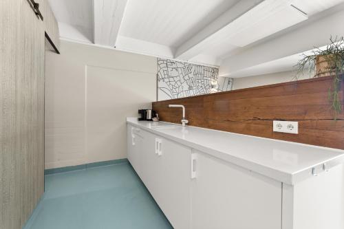 eine Küche mit weißen Schränken und blauen Böden in der Unterkunft Beachrooms Pier 7 in Vlissingen