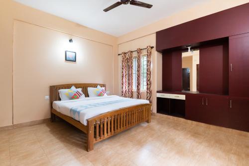 een slaapkamer met een bed en een televisie. bij OYO Home Vedica Home Stays in Ambalavayal