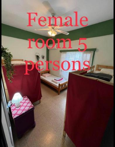 a room with two beds and a sign that reads female room persons at Past or Tail hostel in Larnaka