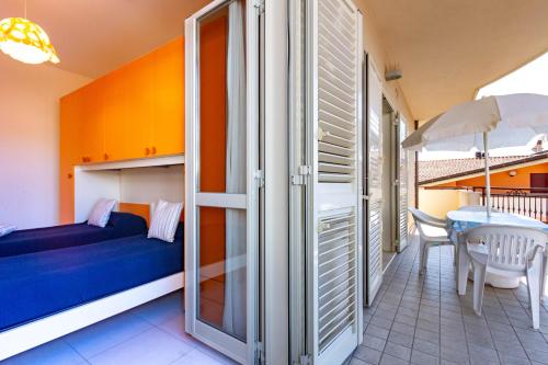 1 dormitorio con 1 cama y 1 mesa con sombrilla en Appartamento Minerva int5 - MyHo Casa en Tortoreto