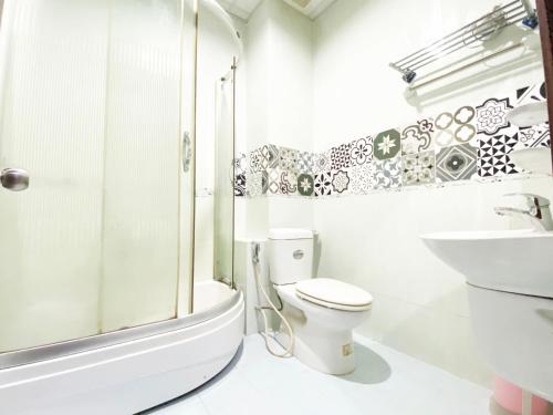 胡志明市的住宿－Cozi 5 Serviced Apartment，白色的浴室设有卫生间和水槽。