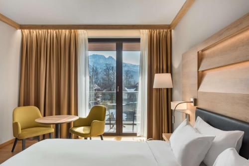 Habitación de hotel con cama, mesa y sillas en Radisson Blu Hotel & Residences, en Zakopane