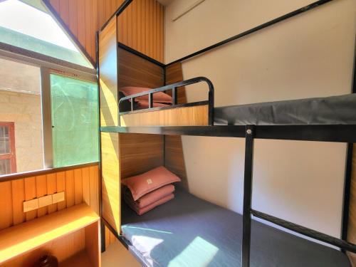 a room with two bunk beds and a window at Meow! Marcia Youth Hostel in Pingtan