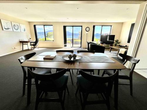 a dining room with a table and chairs and a living room at kunanyi horizons - Hobart in Tranmere
