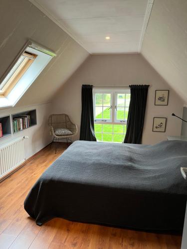 sypialnia z dużym łóżkiem i oknem w obiekcie Ruime vakantiewoning in de natuur w mieście Olst