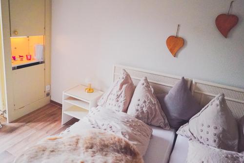 a room with a couch with pillows and a heart on the wall at Lake Rooms in Därligen