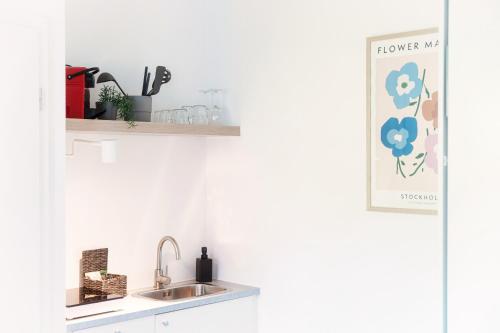 a kitchen with a sink and a shelf at Le Betulle Studios by Quokka 360 - studio apartments by the Origlio lake in Origlio