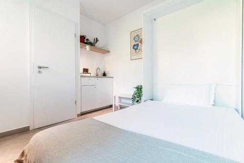 a white bedroom with a bed and a closet at Le Betulle Studios by Quokka 360 - studio apartments by the Origlio lake in Origlio