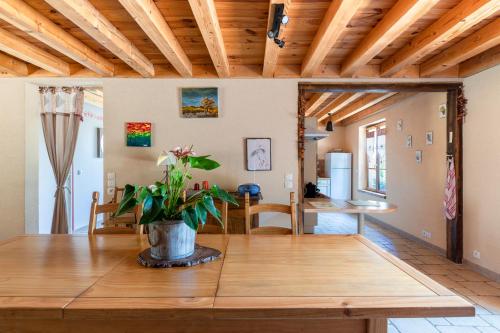 a living room with a wooden ceiling and a table at Gîte avec vue imprenable in Fougerolles