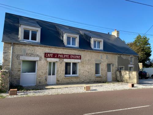 un bâtiment en brique avec un panneau indiquant le magasin de meubles Café i dans l'établissement Café de la Liberté, à Sainte-Mère-Église