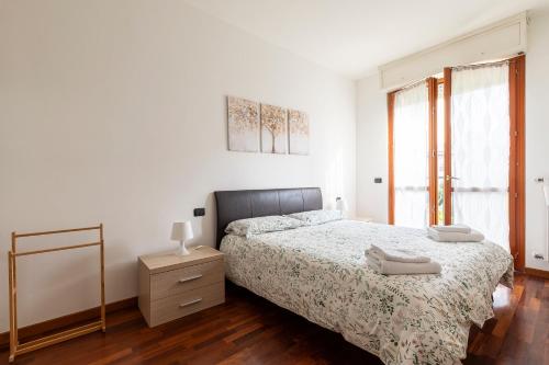 ein Schlafzimmer mit einem Bett, einer Kommode und einem Fenster in der Unterkunft Casty Sweet Home - parcheggio privato gratuito in Mailand