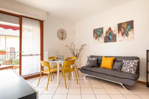 ein Wohnzimmer mit einem Sofa, einem Tisch und Stühlen in der Unterkunft Casty Sweet Home - parcheggio privato gratuito in Mailand