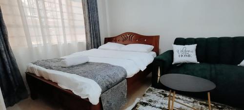 a bedroom with a bed and a couch and a chair at Premier Stays Ruiru in Ruiru