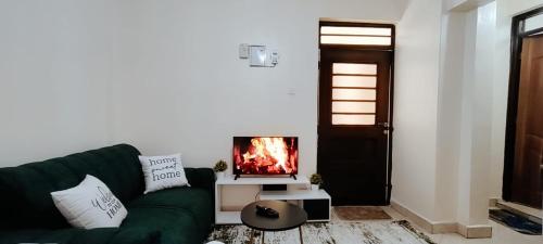 a living room with a green couch and a fireplace at Premier Stays Ruiru in Ruiru