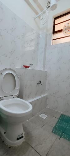a white bathroom with a toilet and a shower at Premier Stays Ruiru in Ruiru